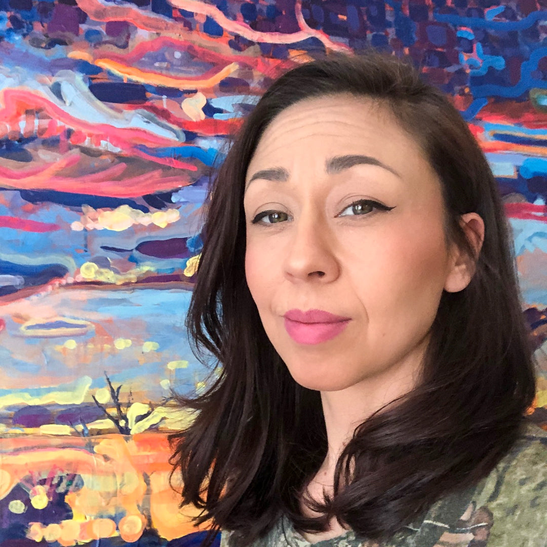 Indigenous artist Laura Leah Lindeman posing in front of one of her artworks/